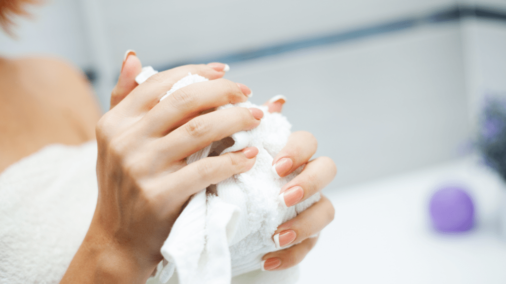 Frauenhände benutzen einen Stofftuchspender - Stofftücher aus Baumwolle oder Zellulose